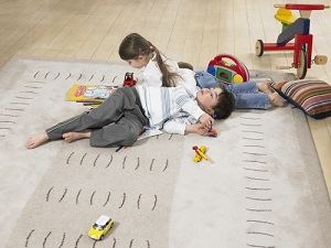 Children playing on secured rug